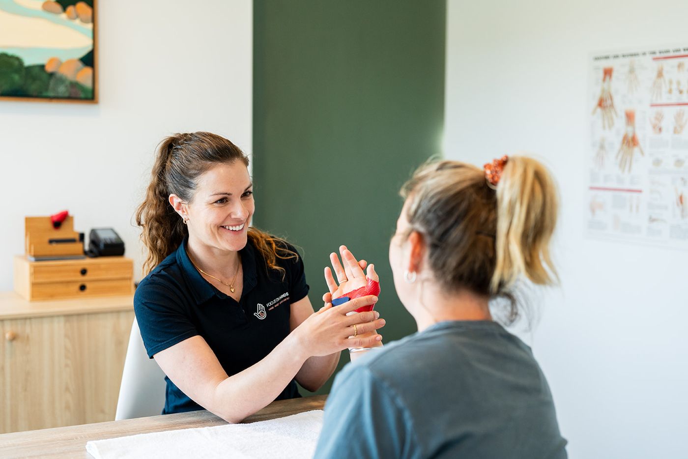 Danielle Crestani guiding a patient through a hand strengthening exercise