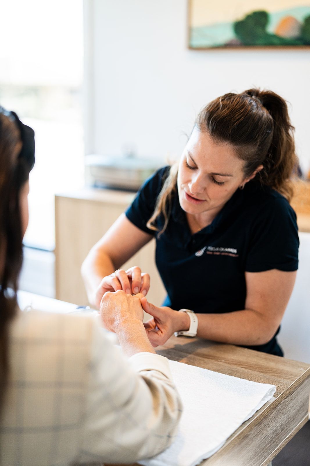 Danielle Crestani assessing a patient's finger movement